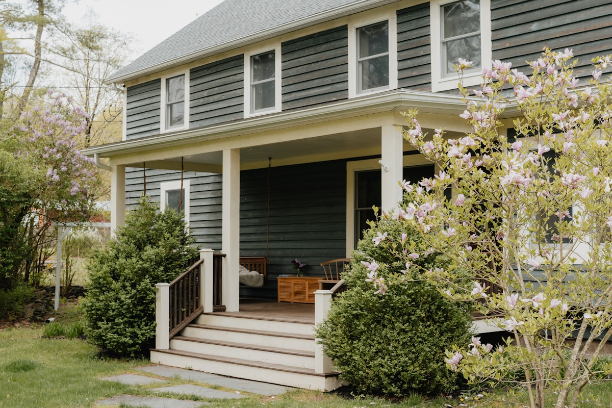 A front porch with sturdy railings beside the entry steps